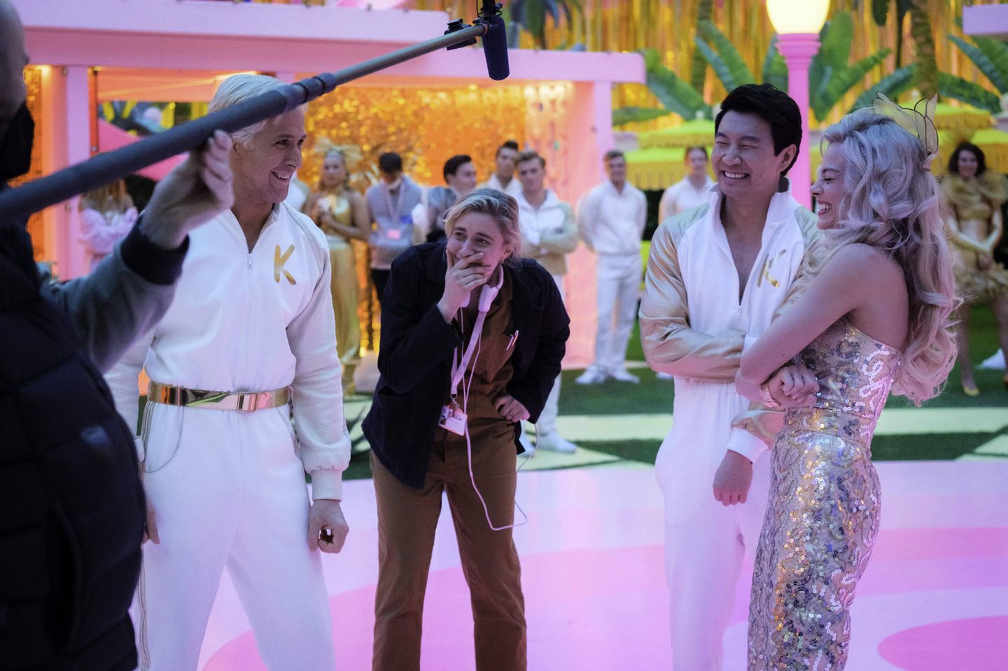 "Shang Chi"-Star Simu Liu spielt eine der unzähligen Ken-Varianten. Hier sieht man ihn als zweiten von rechts am Set zusammen mit Gosling (l.), Robbie (r.) und Produzentin Greta Gerwig (m.). 