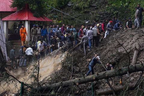 Helfer suchen im Schlamm nach Verletzten nach dem Einsturz eines Tempels in Indien