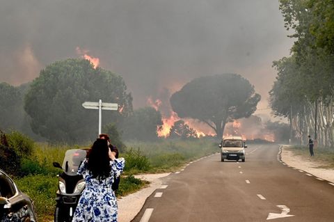 Eine Frau in Frankreich fotografiert einen Waldbrand