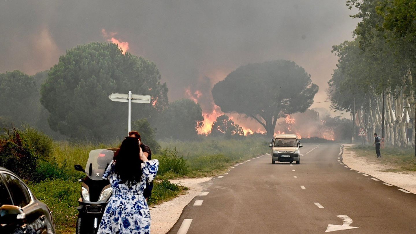 Eine Frau in Frankreich fotografiert einen Waldbrand
