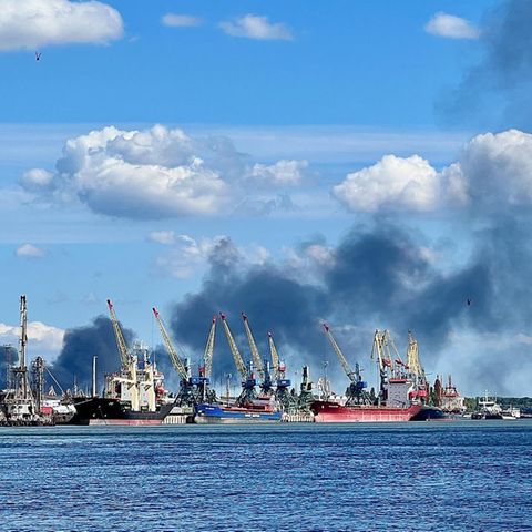 Ein Hafen mit Schiffen und schwarzen Rauchwolken