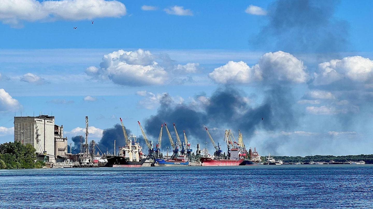 Ein Hafen mit Schiffen und schwarzen Rauchwolken Ein Hafen mit Schiffen und schwarzen Rauchwolken