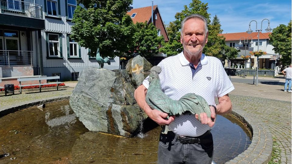 Klaus Elders, Stifter des neuen und alten Bronze-Hahns, steht mit dem vor vier Jahren gestohlenen Hahn vor dem Brunnen, auf dem bereits ein neuer Hahn aus Bronze befestigt ist. Mehr als vier Jahre nach dem Diebstahl kehrte das Wahrzeichen von Goslar-Hahnenklee unverhofft zurück.