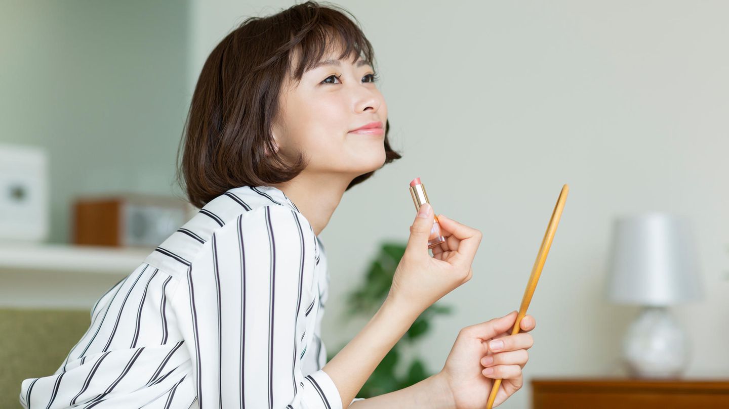 Frau trägt Lippenstift auf
