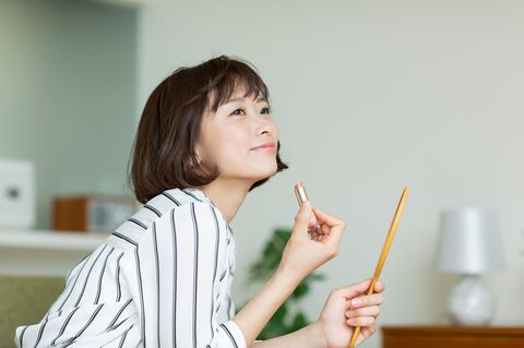 Frau trägt Lippenstift auf