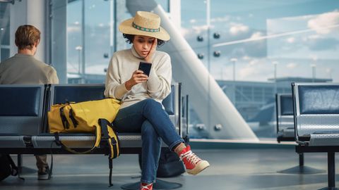 Frau sitzt am Flughafen