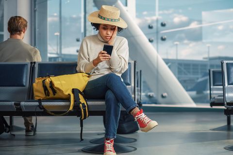 Frau sitzt am Flughafen