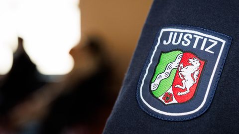 Das Wappen von Nordrhein-Westfalen ist auf dem Ärmel eines Justizbeamten im Gericht in Detmold zu sehen