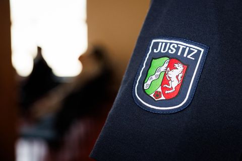 Das Wappen von Nordrhein-Westfalen ist auf dem Ärmel eines Justizbeamten im Gericht in Detmold zu sehen