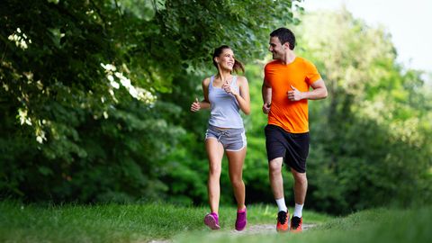 Jogging-Outfit: Junges Paar beim Lauftraining auf einem Waldweg