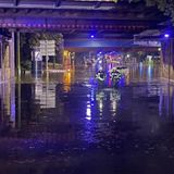 Zwei Feuerwehrleute waten durch das knietiefe Wasser einer Unterführung in Gelsenkirchen, Nordrhein-Westfalen. Heftige Regenfälle haben eine komplette Straße im Stadtteil Schalke überflutet.