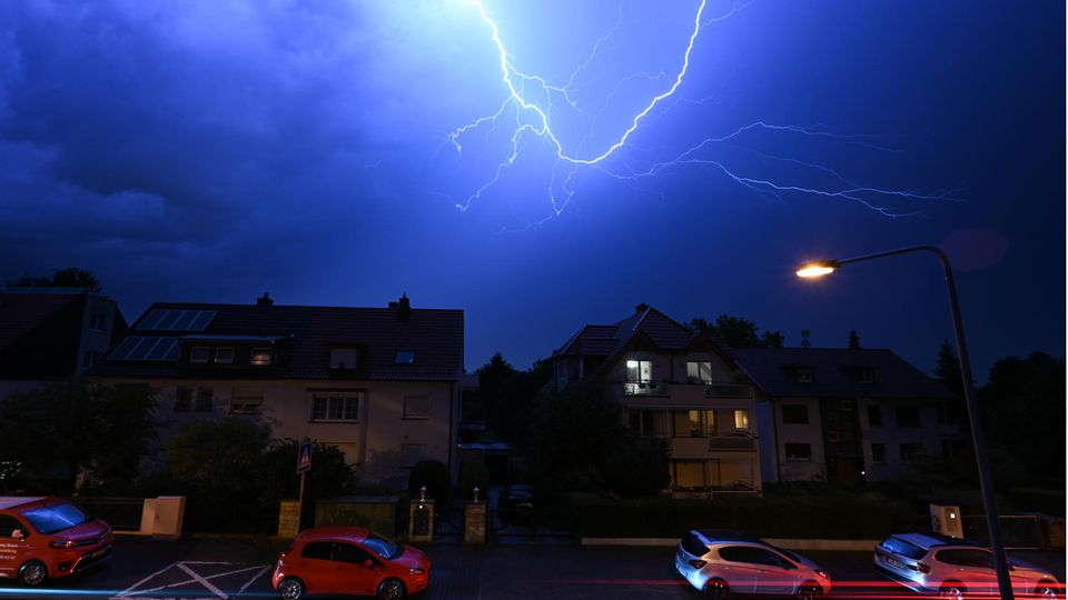 Blitze entladen sich am Abendhimmel während eines schweren Gewitters über den Häusern im Stadtteil Sachsenhausen (Frankfurt)