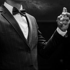 Veganes Parfum: Ein Mann in Anzug duftet sich mit veganem Parfum ein