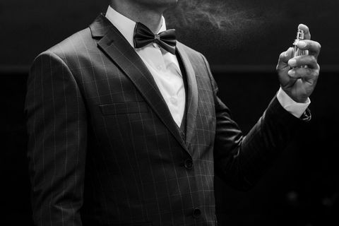 Veganes Parfum: Ein Mann in Anzug duftet sich mit veganem Parfum ein