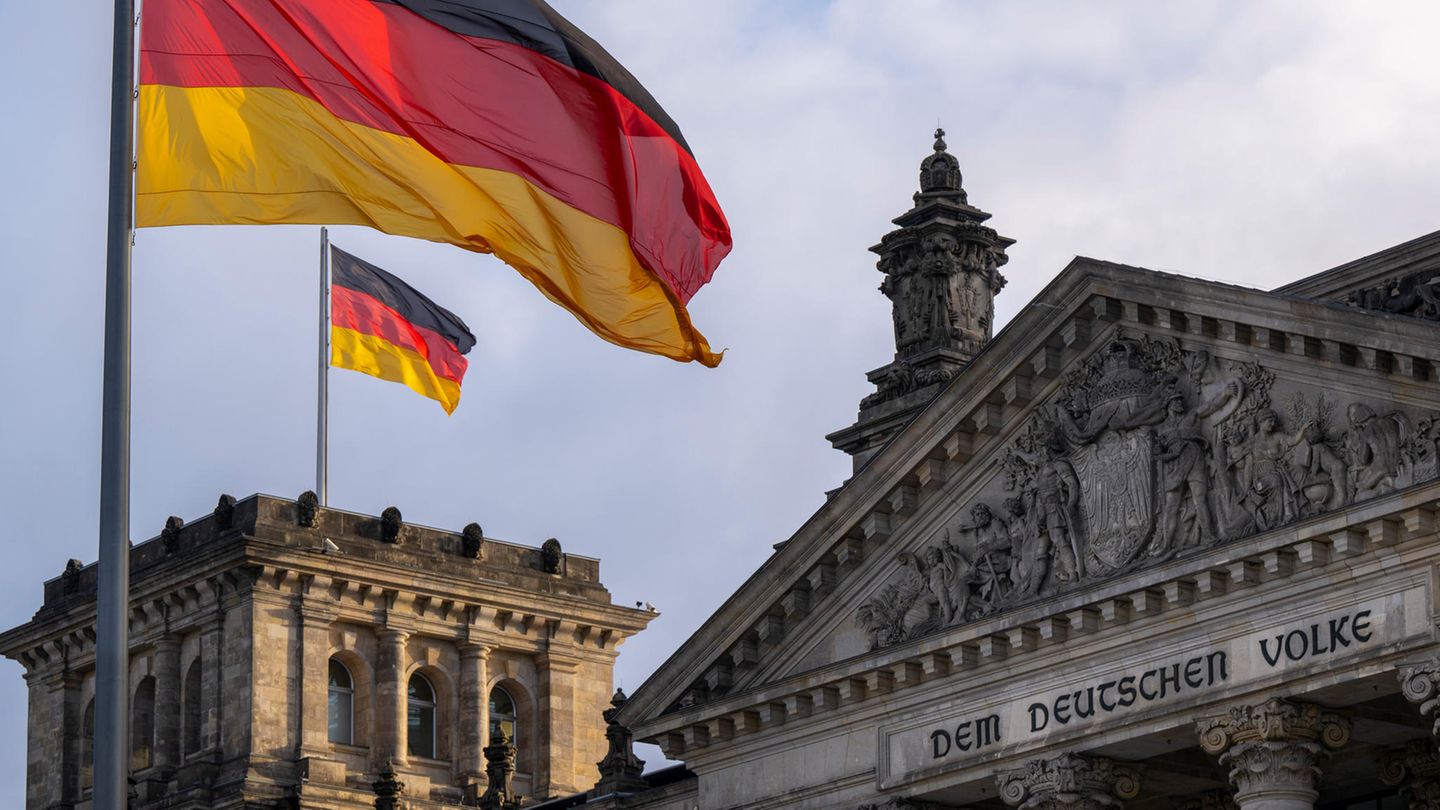Die Deutschlandfahnen auf dem Reichstagsgebäude, dem Sitz des deutschen Bundestags, wehen im Wind
