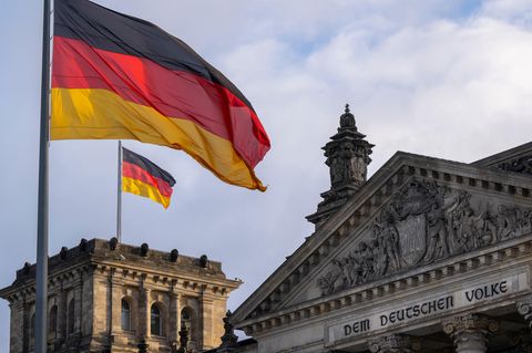 Die Deutschlandfahnen auf dem Reichstagsgebäude, dem Sitz des deutschen Bundestags, wehen im Wind