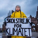 Greta Thunberg in ihrer ikonischen gelben Regenjacke mit ihrem Schild auf dem "Skolstrejk för Klimatet" steht