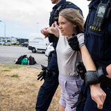 Greta Thunberg wird von zwei Polizisten weggetragen