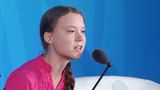 Greta Thunberg in rosa-farbener Bluse am Mikrofon