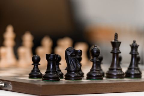 Schachfiguren stehen vor Spielbeginn auf dem Schachbrett