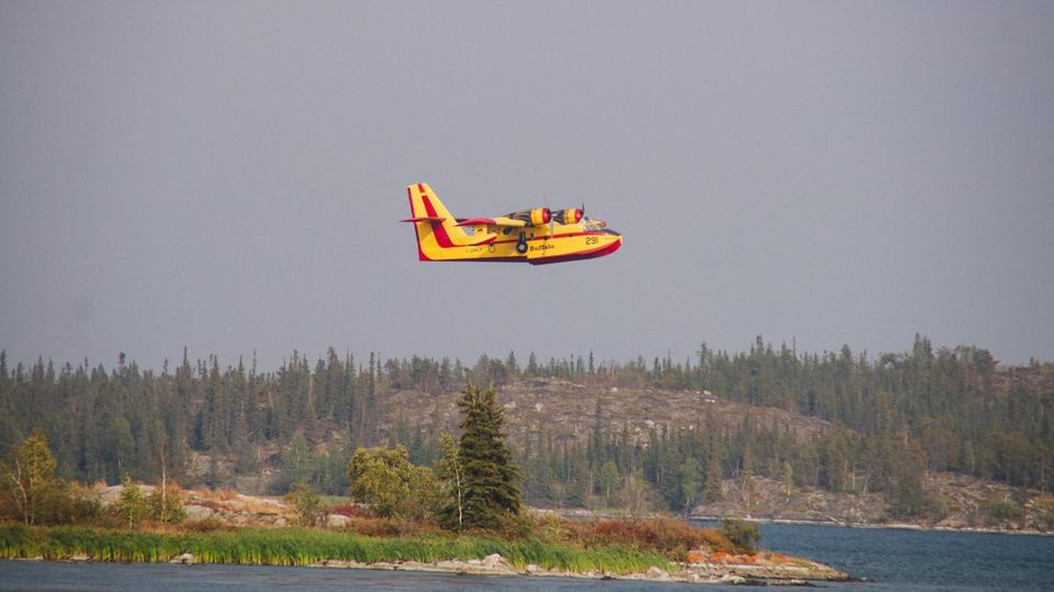 Ein Löschflugzeug hilft bei der Bekämpfung von Waldbränden in der Nähe von Yellowknife, Hauptstadt der Nordwest-Territorien. In Yellowknife dauert die Evakuierung der rund 20.000 Einwohner an, während die Feuer nur noch wenige Kilometer von der Stadtgrenze entfernt
