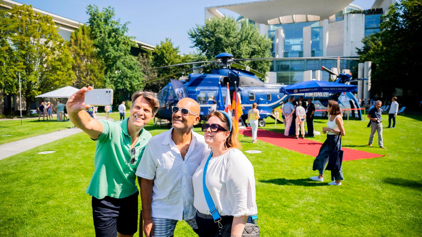 Drei Menschen machen ein Selfie mit dem Hubschrauber der Bundespolizei