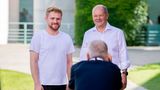 Bundeskanzler Olaf Scholz (SPD, r) lässt sich mit einem Besucher fotografieren