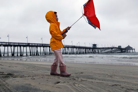 Ein kleines Mädchen kämpft am Imperial Beach in San Diego mit dem Wind.