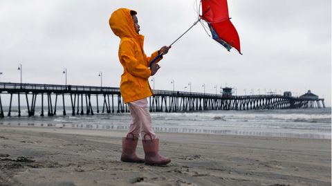 Ein kleines Mädchen kämpft am Imperial Beach in San Diego mit dem Wind.