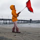 Ein kleines Mädchen kämpft am Imperial Beach in San Diego mit dem Wind.
