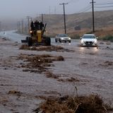 In Palmdale versuchen Autofahrer auf einer überfluteten Straße an einem Pflug vorbeizukommen.