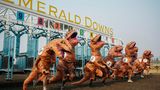 Menschen in T-Rex-Kostümen preschen aus der Startbox für das Meisterschaftsrennen