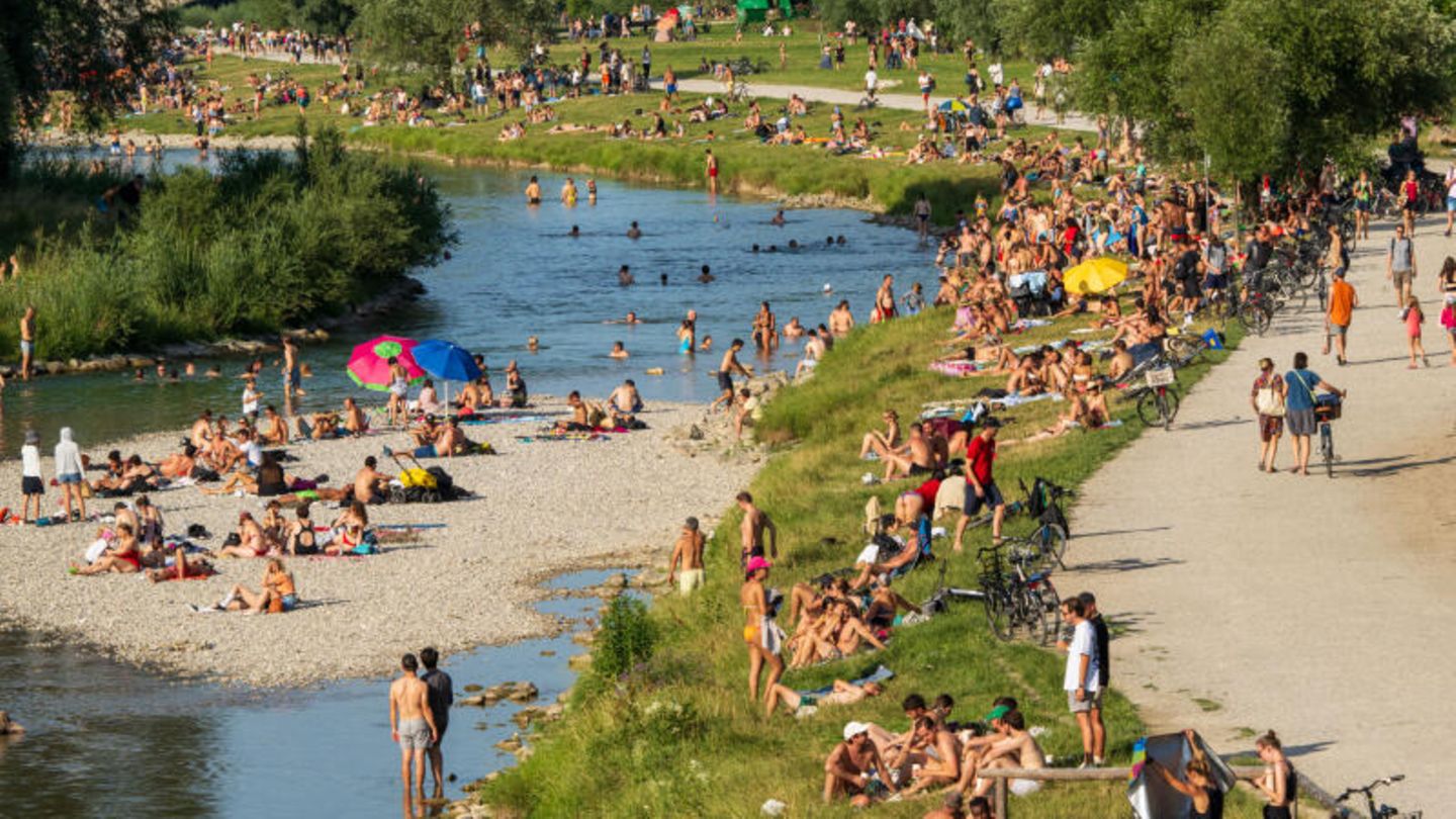 Menschen suchen Mitte Juli am Ufer und in der Isar Abkühlung von den hochsommerlichen Temperaturen in Bayern