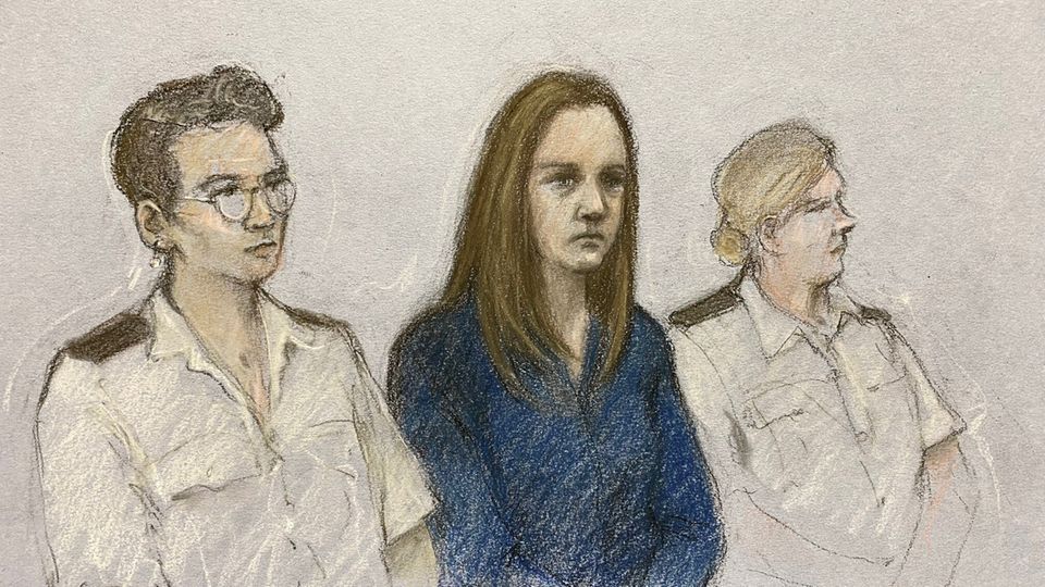 Gerichtszeichnung zur Urteilsverlesung im Fall Lucy L. Die Angeklagte sitzt zwischen zwei Personen. Sie trägt lange glatte Haare