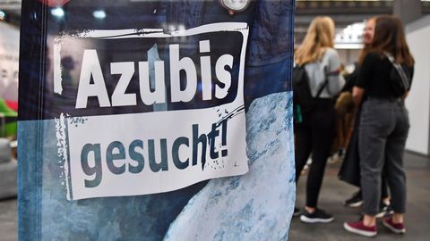 Eine Fahne mit der Aufschrift "Azubis gesucht", im Hintergrund eine Gruppe junger Frauen