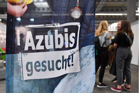 Eine Fahne mit der Aufschrift "Azubis gesucht", im Hintergrund eine Gruppe junger Frauen