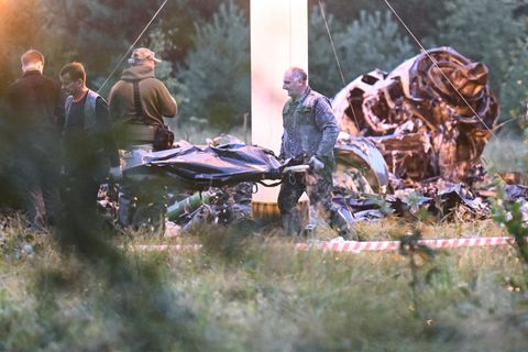 Menschen tragen einen Leichensack aus dem Wrack eines abgestürzten Privatjets