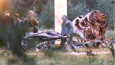 Menschen tragen einen Leichensack aus dem Wrack eines abgestürzten Privatjets