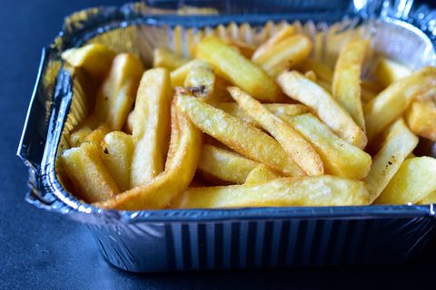 Fastfood: Pommes Frites liegen in einer geriffelten Aluschale