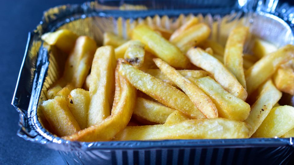 Fastfood: Pommes Frites liegen in einer geriffelten Aluschale