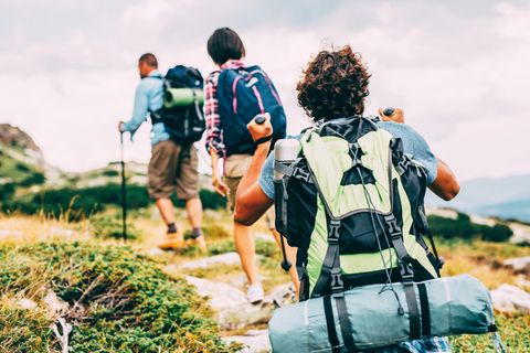 Geschenke für Wanderer und Outdoorfans: Drei Wanderer mit Gepäck auf einem Trailpfad