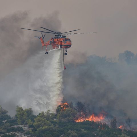 Ein Hubschrauber wirft Wasser über einem Waldbrand in Griechenland ab