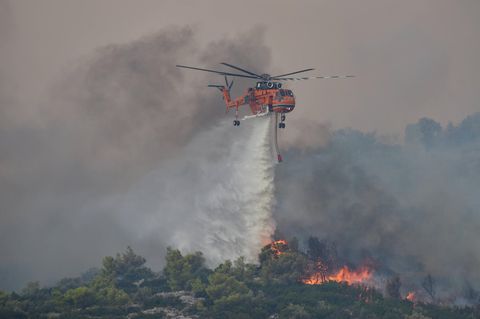 Ein Hubschrauber wirft Wasser über einem Waldbrand in Griechenland ab