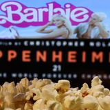 Eine Tüte Popcorn vor einer Kinoleinwand, auf der Barbie und Oppenheimer zu sehen sind