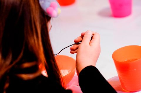 Ein Kind isst in einer Jugendkirche den Nachtisch zu seinem Mittagessen