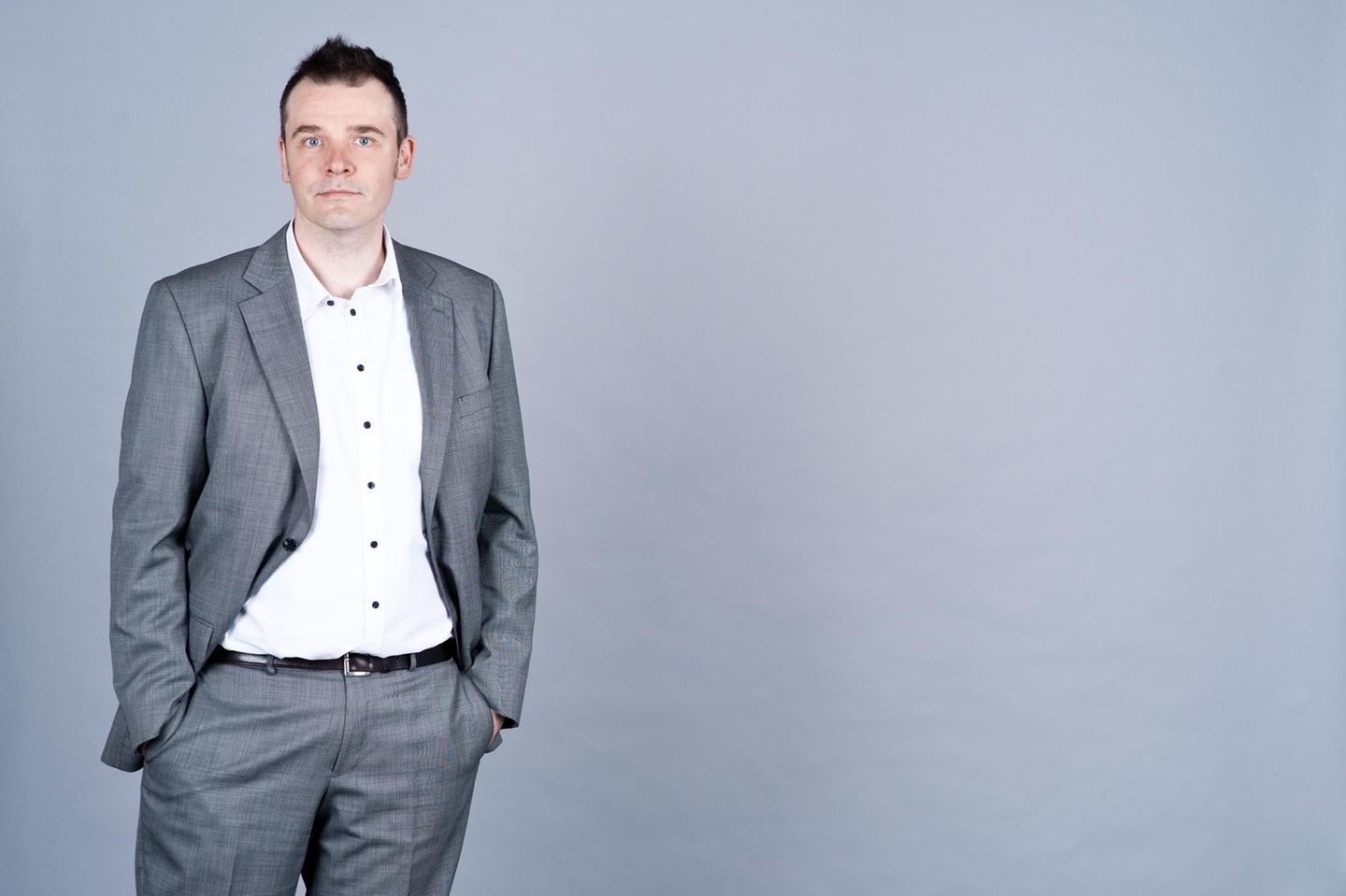 Ein Mann in Anzug vor grauen Wand