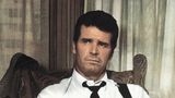 Philip Marlowe: Ein Mann mit loser Krawatte sitzt auf einem Stuhl und schaut ernst