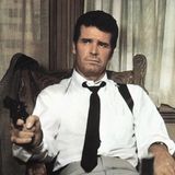 Philip Marlowe: Ein Mann mit loser Krawatte sitzt auf einem Stuhl und schaut ernst