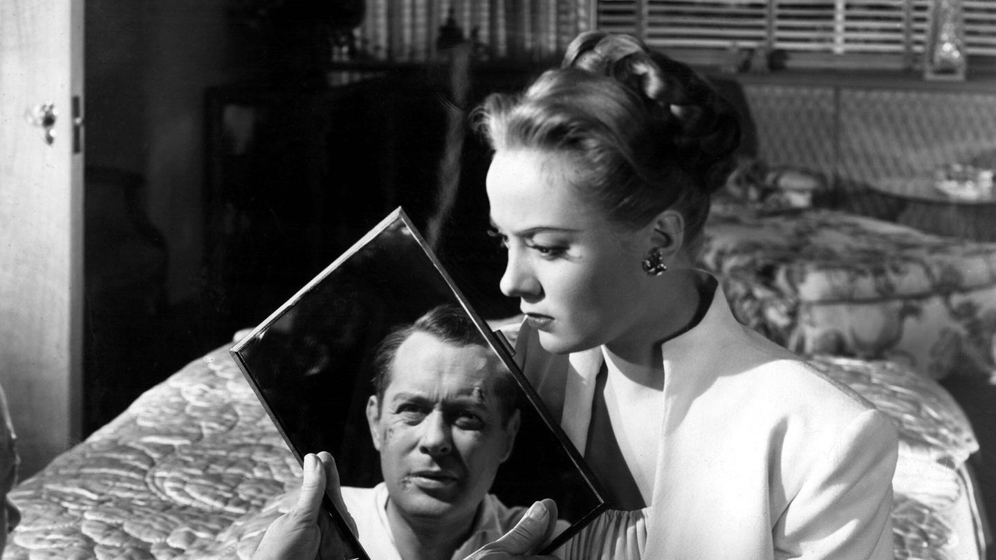 Philip Marlowe: Eine Frau sitzt auf einem Bett. Auf einem Spiegel ist ein Mann zu sehen