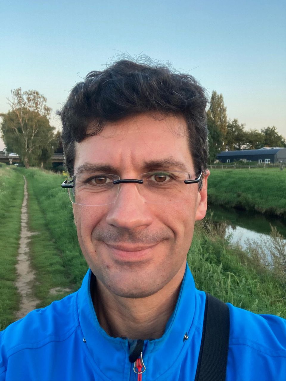 Ein Mann mit dunklen Haaren und Brille in der Natur